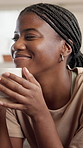Thinking, woman and smile with coffee at house to start day, calm morning and ideas for weekend. African person, thoughtful and beverage with reflection, remember past and nostalgia memory in lounge
