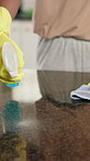 Person, hands and cleaning surface with spray bottle in kitchen for housekeeping service or hygiene. Closeup, homeowner or wiping with cloth or chemical detergent for dust or dirt removal in house
