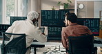 Businessmen, stock market and discussion computer in office for company finance or investment. Back view, male people or broker with technology, screen or cryptocurrency for trading app in workplace