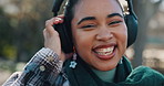 Face, woman and laughing with music, nature and university student with headphones and subscription. Outdoor, happy and person with tech for entertainment, audio and smile for sound, radio and break