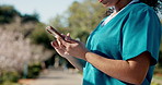 Woman, hands and nurse with phone for medical study, telehealth app or research at outdoor park. Closeup, female person or scrolling with mobile smartphone for communication or online news in nature