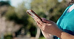 Nurse, hands and typing with phone for medical study, telehealth app or research at outdoor park. Closeup, female person or scrolling with mobile smartphone for UX, communication or news in nature