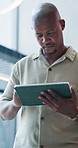 Below, business and black man with tablet in office for research, email editor and proofreading story. Journalist, reading and digital for editing draft, review feedback and schedule for publication
