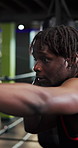 Boxing, punch and black man in gym for training, workout or MMA challenge with power. African person, boxer and fitness for combat sports, fight practice and exercise for self defense with bokeh