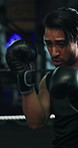 Sport, punch and man boxing with gloves in gym, strength and cardio training in practice match. High intensity, skill development and people sparring in ring, powerful impact or defence in fist fight