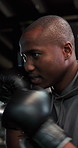 Boxer, man and workout in gym with punching bag, practice and training for fighting competition. Boxing, athlete and person in fitness center with gloves, exercise and preparation for mma match.