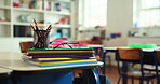 Glasses, books and stationary on table in classroom for education, learning and knowledge growth. Equipment, workbook and study material for lesson, grading homework and academic activity at school