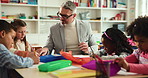Help, man and students in classroom, education and drawing with child development. Group, teacher and kids in school, learning and knowledge with growth, teaching and discussion with creativity