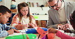 School, teacher and man with students, writing and literature lesson with group, help and education. Teaching, children and knowledge for curriculum, growth and development of kids in elementary