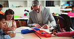 Learning, man and students in classroom, education and help with child development. Group, teacher and children in school, creativity and knowledge with growth, drawing and communication with ideas
