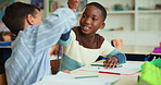 Drawing, fist bump and student boys in class together for development, education or learning. Notebook, picture and success with children friends at desk in classroom of school, excited for growth