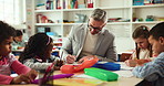 Creativity, man and students in classroom, education and help with child development. Conversation, teacher and kids in school, learning or knowledge with growth, drawing or teaching with support
