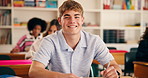 Smile, face and student in high school with writing test, exam or assessment for education. Happy, learning and portrait of boy teenager with books for notes for studying in classroom at campus.