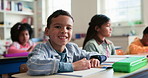 Smile, education and face of child in classroom at elementary school with confidence for learning. Happy, student and portrait of boy kid with pride for assessment at academic lesson at campus.