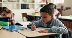 Education, writing and kid in classroom at school for test, assessment or project for learning. Color pencil, student and boy child with notebook for drawing with creative assignment at campus.