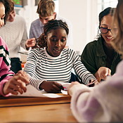 Group, classroom and students in discussion with notes for ...