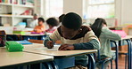 Learning, writing and kid in classroom at school for test, assessment or project for education. Color pencil, student and boy child with notebook for drawing with creative assignment at campus.