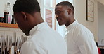 Black man, chef and discussion at kitchen, restaurant or team for planning, advice or listen for training. People, mentor and talk with learning, culinary arts and cuisine with cooking at workplace