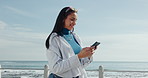 Phone, smile and woman at promenade for travel, vacation or reading text on holiday. Mobile, ocean and person outdoor for adventure, trip or message for communication online with app for social media