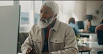 Creative, man and reading on computer in office for research, review article and editing draft. Mature person, coworking and pc for proofreading, report news and story headline on publication website