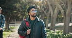 Student, man and thinking with outdoor walk for education, learning and development at campus. Person, idea and backpack in park with commute for scholarship, knowledge and learning at university