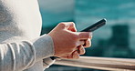 Hands, phone and texting on balcony with contact, scroll and notification for networking in city. Person, smartphone and click with mobile application, web chat or social media with post on rooftop
