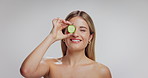 Woman, skincare and cucumber with face in studio, smile and mockup space with nutrition on white background. Girl, model and happy with organic fruit for detox, diet benefits and beauty in Germany