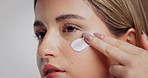 Beauty, woman and apply face cream in studio for hydration treatment, moisturizer or hyaluronic acid. Skincare, person and SPF lotion on white background for healthy skin, self care routine and glow