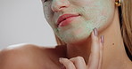 Hands, skincare and clay mask in studio with woman, touch or application for dermatology on background. Person, model and natural cosmetics for beauty benefits, closeup and facial transformation