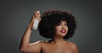 Woman, face and hairspray with afro in studio, smile or test beauty product on background. Girl, bottle and happy with space for benefits, growth and collagen for texture with cosmetics in Brazil
