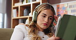 Annoyed, headphones and woman with tablet in home for sound, tech and subscription. Online, entertainment and person with app for social media, browsing and disappointed on break in living room