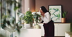 Woman, smell and flowers aroma at house for special occasion, bouquet present and bloom fragrance. Smile, female person and plants scent of gift, home decoration and floral arrangement in living room