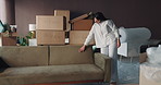 Woman, sofa and moving in new home with cover for furniture investment or property in apartment. Female person, homeowner or checking quality with couch, boxes or interior for fresh start in house