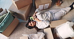 Happy woman, phone and relax with boxes in new home above for relocation, fresh start or investment. Top view, female person or homeowner lying on floor with mobile smartphone for unpacking in house