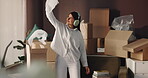 Woman, headphones and dance with boxes for unpacking, energy and celebrate in new house. Tossing paper, fun and person with music for property, real estate or happy for mortgage and cardboard package
