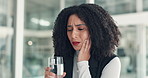 Woman, toothache and water at office with stress, fatigue or drink with oral hygiene at company. African person, glass and cavity with pain in mouth, dental care or gum disease at creative agency