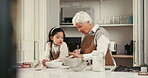 Baking, grandmother and grandchild with talking in kitchen for tips, learning and culinary skills. Family, girl and senior woman in home with mixing ingredients, teaching cake recipe and development