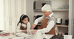 Baking, learning and child with grandma in kitchen for bonding, fun or development together. Happy, ingredients and girl kid helping senior woman with preparing dessert, cake or cookies in home.