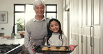 Baking, tray and face of grandmother with child in kitchen for cookies, biscuits and sweet treats. Family, home and portrait of grandma and girl for bonding, love and learn to make recipe on weekend