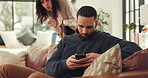 Man, fight and ignore with phone on sofa for argument, disagreement or conflict in home. Frustrated couple, woman and separation with mobile smartphone for living room dispute or cheating affair