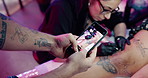 Hands, photography and phone screen with tattoo in studio for leg art, design and social media post. Small business, client and permanent body ink in parlor for aesthetic, creative process and artist