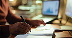 Hands, computer and businessman writing in notebook for trading details, price targets or deadline. Graphs, night trader and tech with notes in office for stock market strategy or information journal