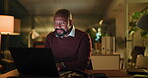 Business, man and laptop in office at night for publication deadline, creative research or article. Journalist, mature black person and smile with technology at agency for editor feedback or overtime