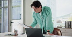 Businessman, accountant and reading with document on laptop for financial planning in office. Man, accounting or employee checking paperwork for company finance, revenue or statistics in workplace