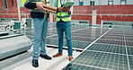 Solar panel, discussion and men on roof with tablet, development and material on building. Team, sustainability and engineer on site with tech, photovoltaic or installation for renewable energy.
