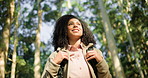 Backpacking, hiker and woman with smile, forest or travel in nature on break, tourism and fresh air. Outdoor, traveller and African person on hike, low angle and happy for adventure in woods and trip