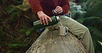 Man, hands and hiker with flask on tree for beverage, drink or break in forest, jungle or nature. Male person, bottle and cup with water for natural sustainability, trekking stop or rest in woods