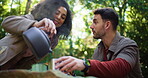 Camping, pouring and kettle with couple in nature for brewing coffee, trekking rest stop and help. Adventure holiday, gas canister and tea pot with people and drink in forest for travel and trip