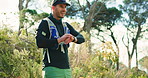 Fitness, check and man in forest with smart watch for outdoor workout, happy runner and step count. Resilience training, smile or person in nature for exercise, monitor heart beat and health benefits