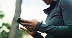 Athlete, online and hands with smartphone in forest, web or check progress on fitness app in nature. Outdoor, wellness and person with mobile for workout goals, browsing and typing on break in woods